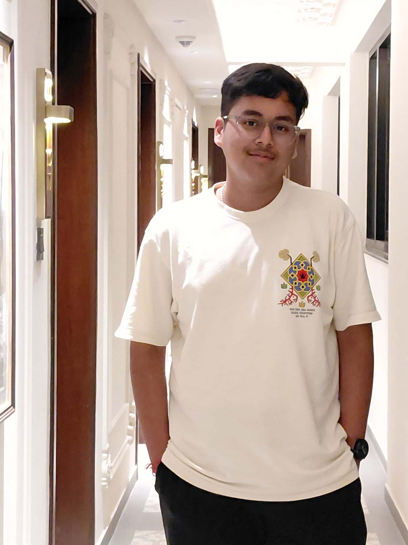 Harshit Murarka in a cream T-shirt, standing in a bright corridor